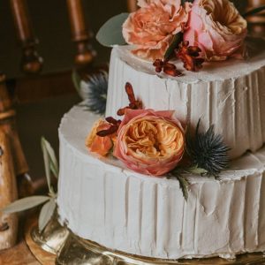 Bröllopstårta uppstruken med smörkräm, dekorerad med levande blommor