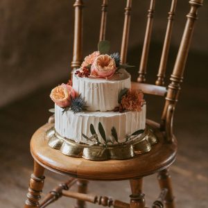 Bröllopstårta uppstruken med smörkräm, dekorerad med levande blommor